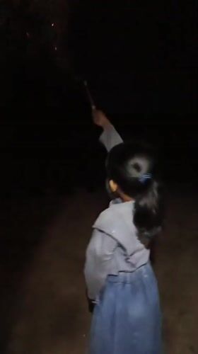 Children play with sparklers during nighttime in Saweuk, Indonesia