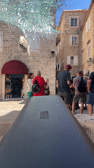 Street musician plays flute in Budva courtyard