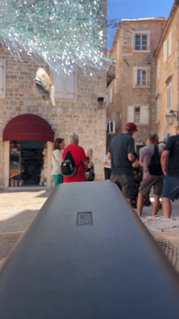 Street musician plays flute in Budva courtyard
