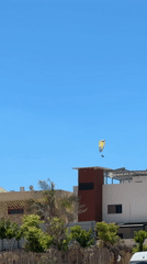 Paragliding over Netanya's modern skyline on clear afternoon