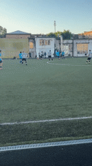 Afternoon pickup soccer match on artificial turf, day into evening