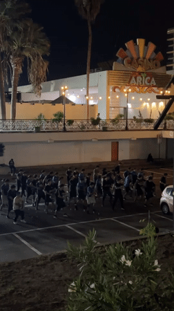 Nighttime group dance performance draws dozens to Arica parking lot