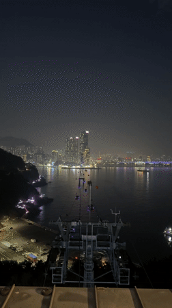 Nighttime cable car views capture Busan skyline and sculptures