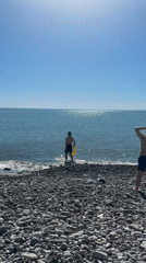 Beach day in Sochi as man enters sea with inflatable ring