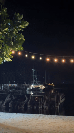 Nighttime marina scene captured from beach in Thailand