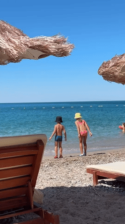 Kids at the turquoise shoreline of a Montenegrin pebble beach