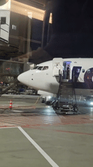 LOT Polish Airlines plane at gate, nighttime airport scene