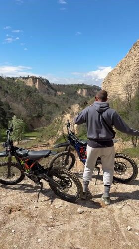Man with dirt bikes overlooks valley near Melnik, Bulgaria