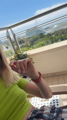 Woman enjoys balcony moment with orange tree in Valencia