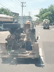 Antique industrial machine transported by truck in Indonesia
