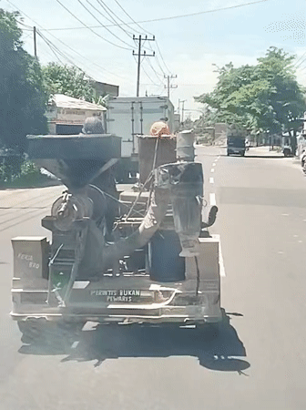 Antique industrial machine transported by truck in Indonesia