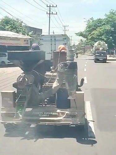 Antique industrial machine transported by truck in Indonesia
