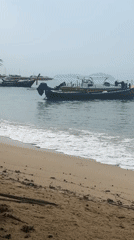 Rawai beach at rest: boats, a kayak, and a beachcombing bird