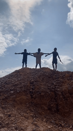 Playing on red cliffs and dirt mounds in Achara, Nigeria
