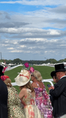 Race day at Royal Ascot, dressed-up crowds and horses on track