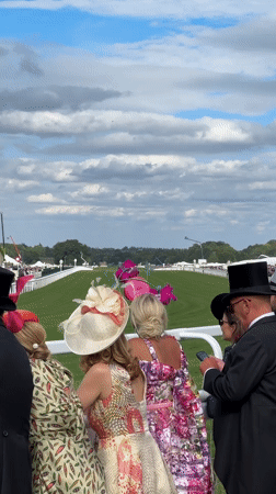 Race day at Royal Ascot, dressed-up crowds and horses on track