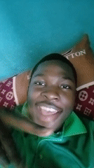 Young man poses cheerfully on designer pillow in Ilorin