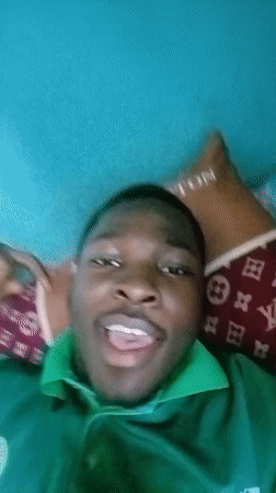 Young man poses cheerfully on designer pillow in Ilorin