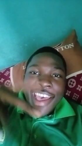 Young man poses cheerfully on designer pillow in Ilorin