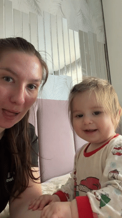 Woman and child share quiet moment on bed in Myaglovo