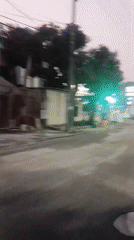 Dusk traffic rolls through a busy Surabaya street
