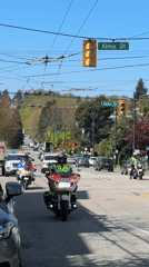 Police motorcade with flashing lights travels through downtown Vancouver