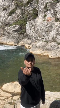 Person gestures at waterfall in Medven, Bulgaria