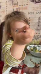 Toddler enjoys messy green meal in Chaikovsky, Russia