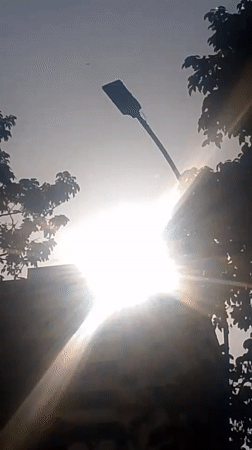 Evening sun creates starburst effect over Caracas buildings