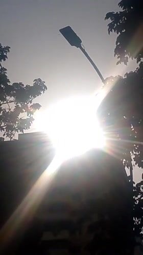 Evening sun creates starburst effect over Caracas buildings