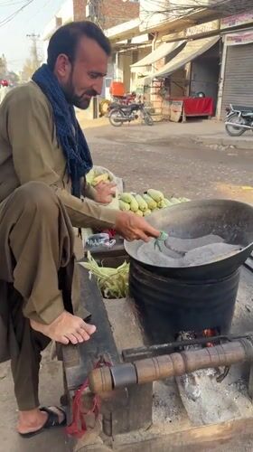 Street vendor roasts corn on mobile cart in Multan