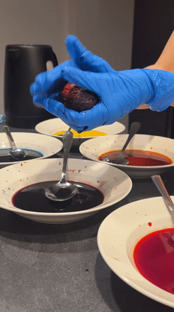 Person arranges colorful liquids on plates in Gudauri