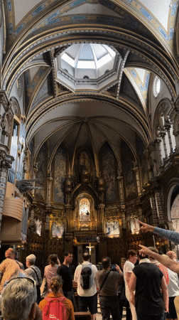 Tourists visit cathedral in Monistrol de Montserrat, light votive candles