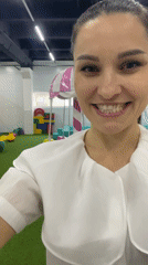 Woman films, dances at Russian playground while child rides carousel