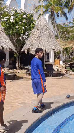Two athletes stretch by resort pool in Porlamar