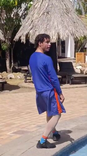 Two athletes stretch by resort pool in Porlamar