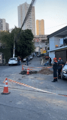 Utility workers conduct evening street excavation in São Paulo