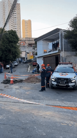 Utility workers conduct evening street excavation in São Paulo
