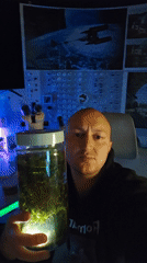 Man displays illuminated aquatic plant jar in Portugal