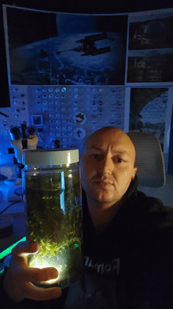 Man displays illuminated aquatic plant jar in Portugal
