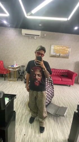 Young adult takes mirror selfie in Kuta barbershop