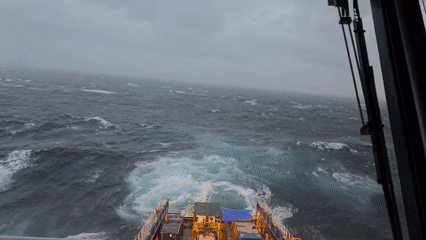 Ship encounters rough seas under grey skies