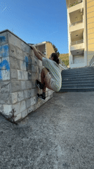 Person vaults stone wall in Montenegro coastal town
