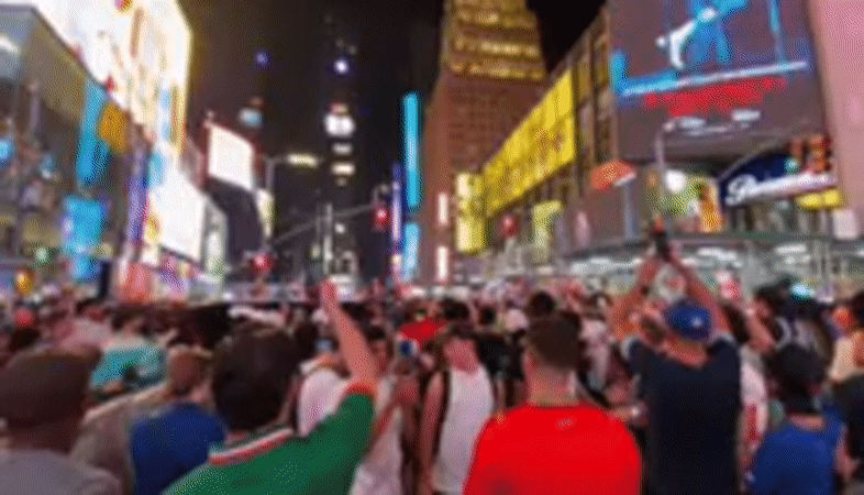 Nighttime crowd gathering in Times Square's bright billboard district