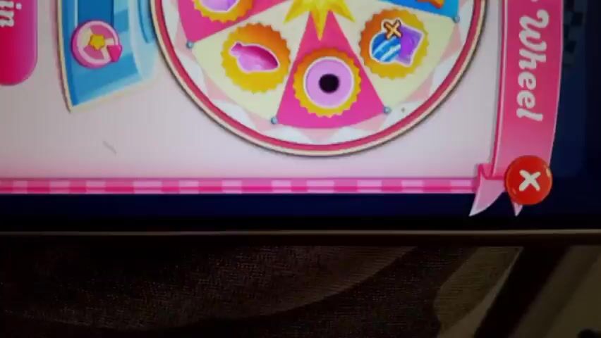 A screen recording shows a game called Booster Wheel. The wheel spins and lands on a blue section with three stars. The wheel then shrinks to the side, and a timer appears in the middle of the screen.