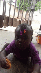 Toddler enjoys meal on concrete floor in Akwanga