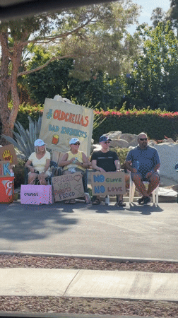 Seven hold encouraging signs during roadside gathering in Indio