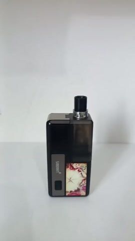 The video shows a person holding a vape device. The device is black and silver with a floral design on one side. The screen displays information such as wattage, voltage, puff count, and puff time. The person presses the buttons on the device, changing the wattage setting.