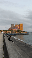 Person uses phone at Chatan waterfront ledge