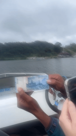 Motorboat passengers travel to lakeside temple complex in Baturiti